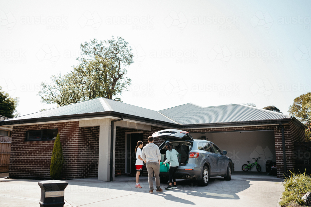 Family loading things into the car boot. - Australian Stock Image