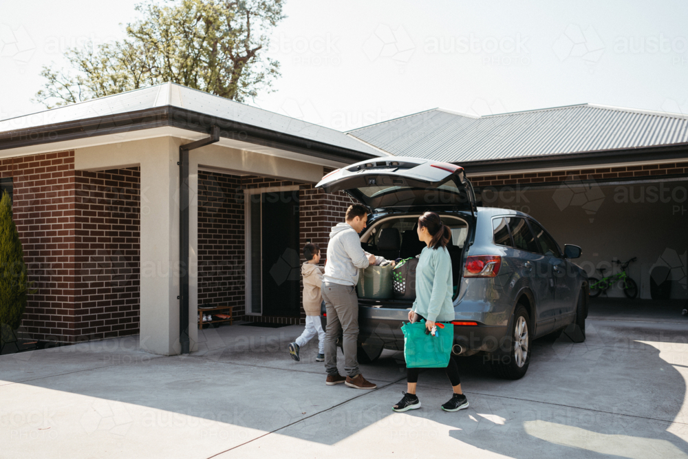 Family loading things into the car boot. - Australian Stock Image