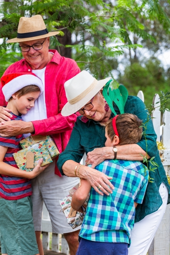 family members hugging at Christmas family gathering - Australian Stock Image