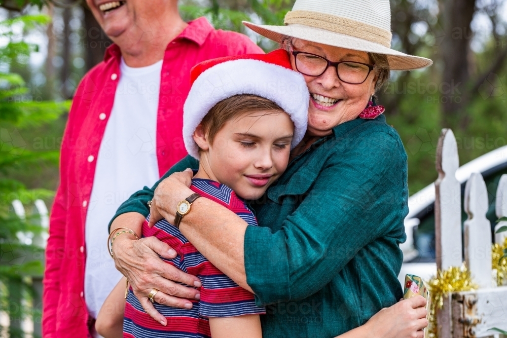 family members hugging at Christmas family gathering - Australian Stock Image