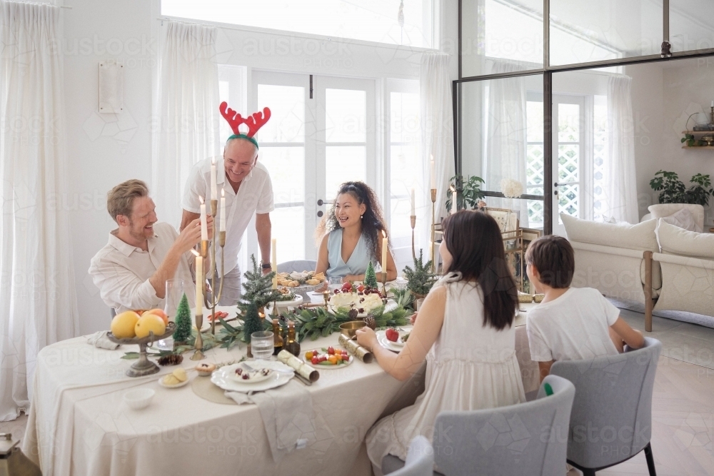 Family of five sitting around Christmas table - Australian Stock Image