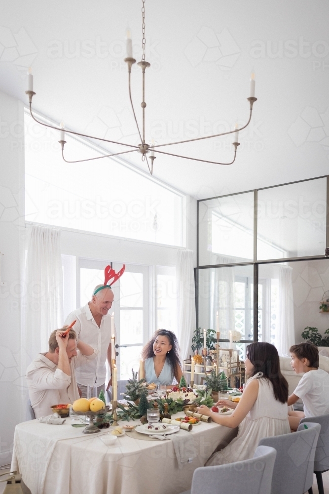 Family of five sitting around Christmas table - Australian Stock Image