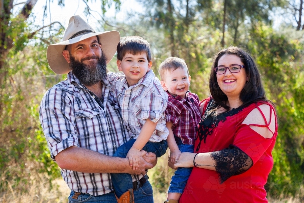 Family of four with two boys smiling together - Australian Stock Image