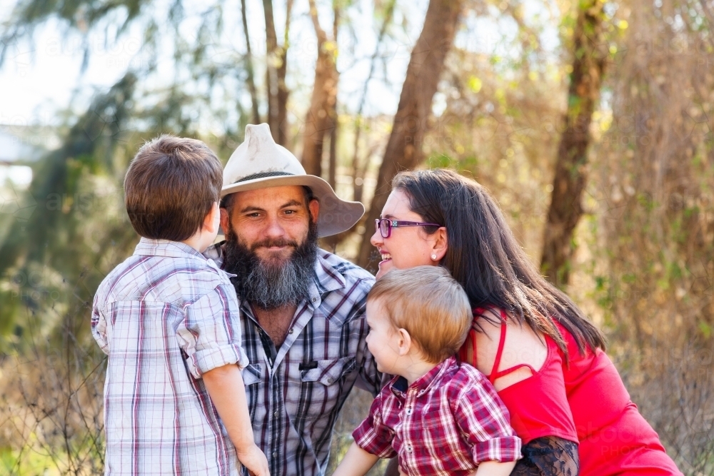 Family of four with two boys smiling together - Australian Stock Image