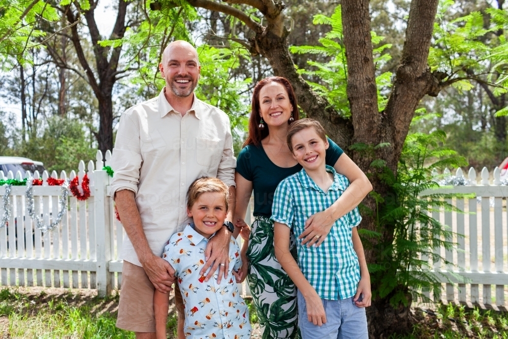 Family portrait under jacaranda tree at Christmas time - Australian Stock Image