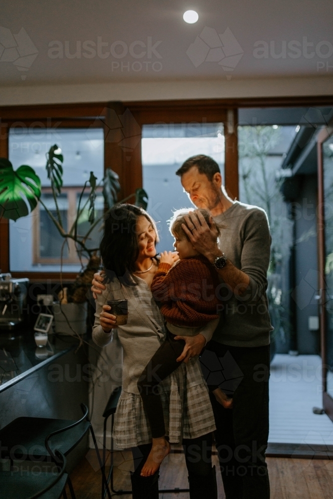 Family with young boy together in home dining room in late afternoon - Australian Stock Image