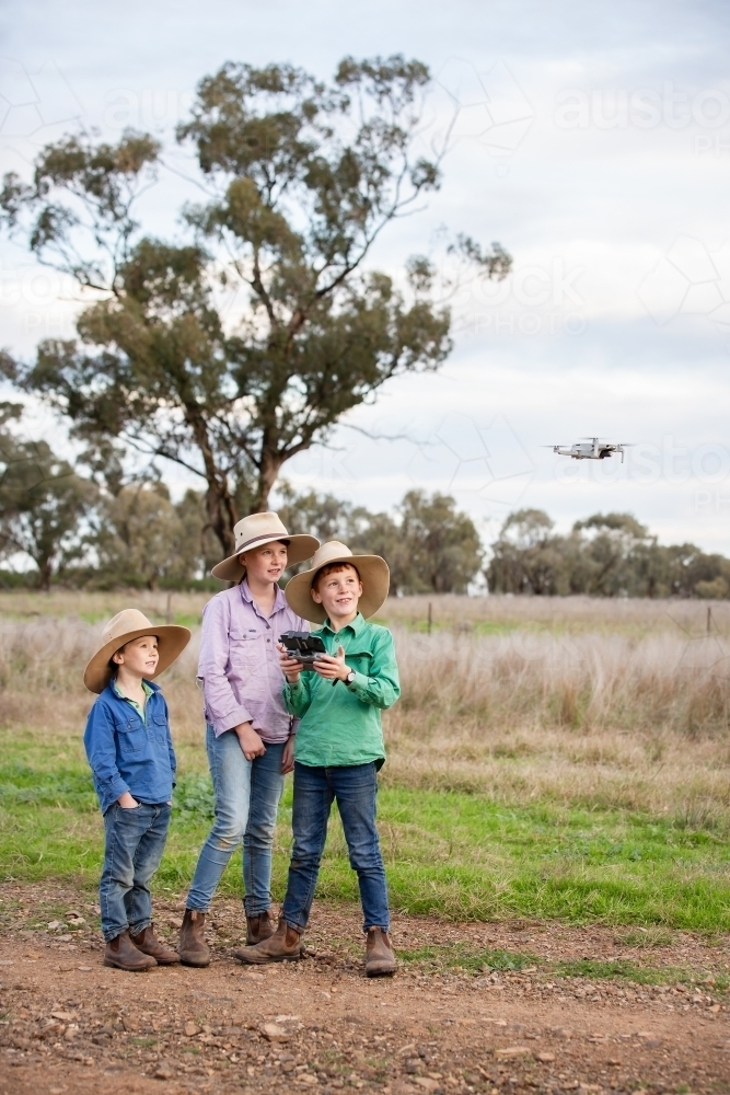 Farm kids using a drone in the paddock - Australian Stock Image