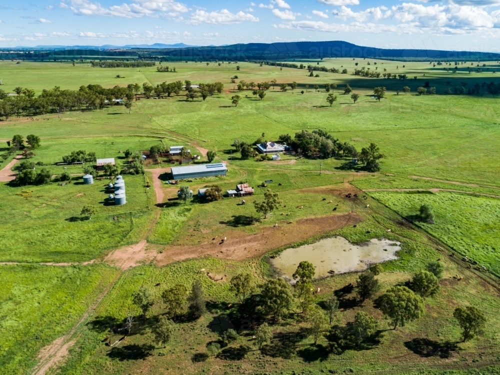 Farm landscape with dam and sunlit paddocks from the air - Australian Stock Image