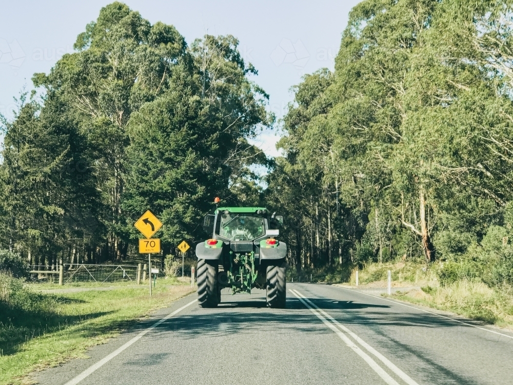 Image Of Farm Tractor Driving On Country Road - Austockphoto