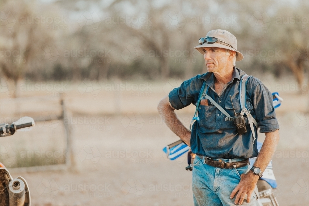 Farmer working in paddock near motorbike - Australian Stock Image