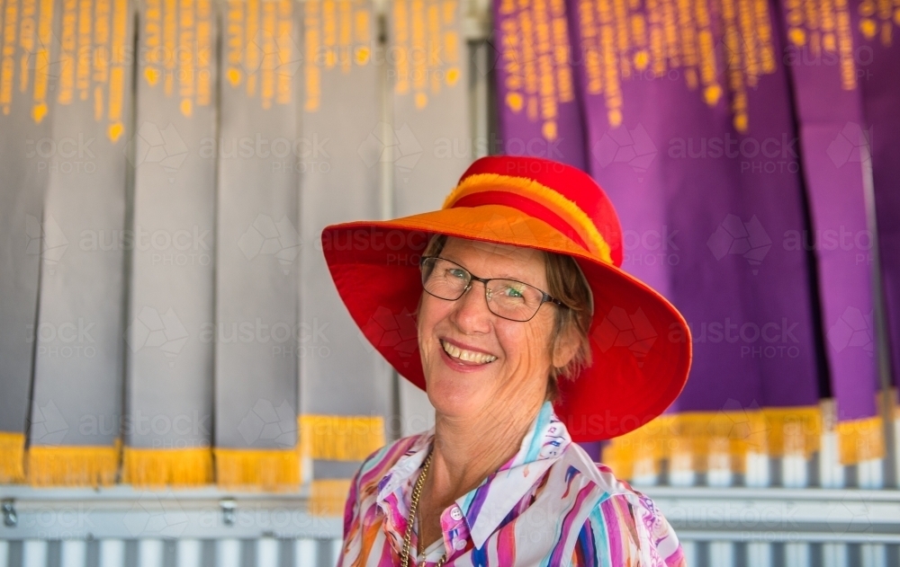 Fashionable elderly woman in hat with award ribbons at Outback Australian picnic race meeting - Australian Stock Image