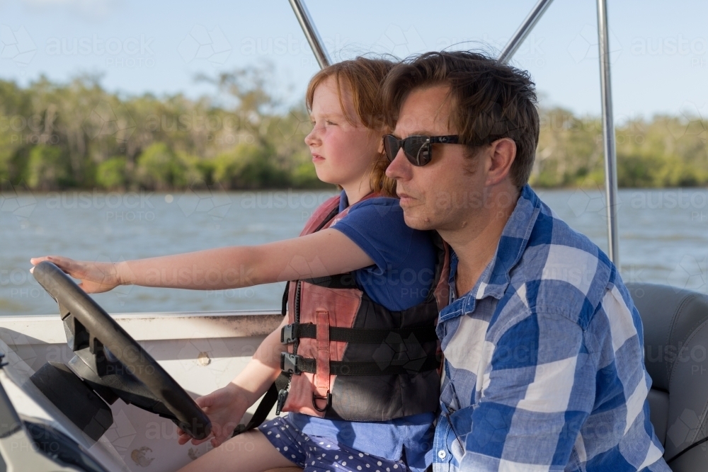 Father and daughter steering a boat - Australian Stock Image