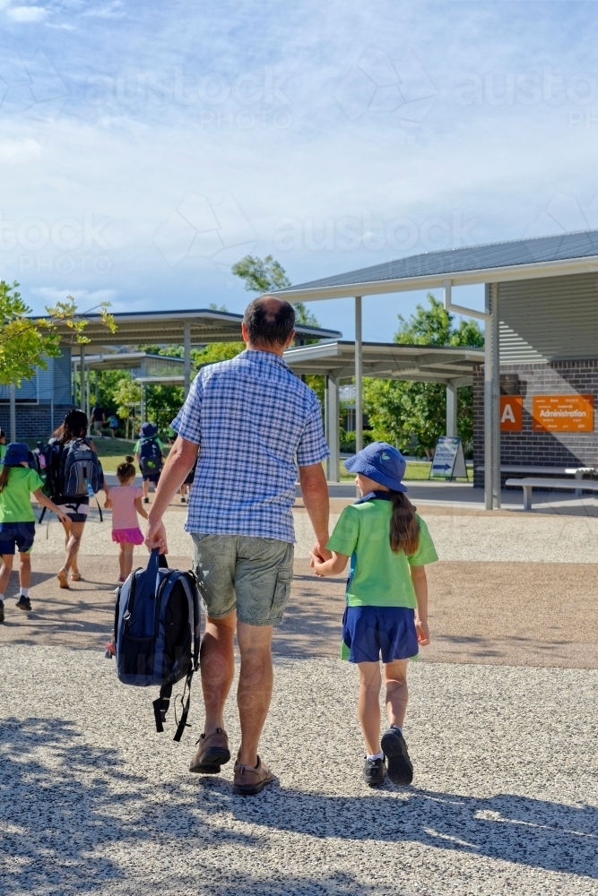 Father and daughter walking to school and to the class room - Australian Stock Image