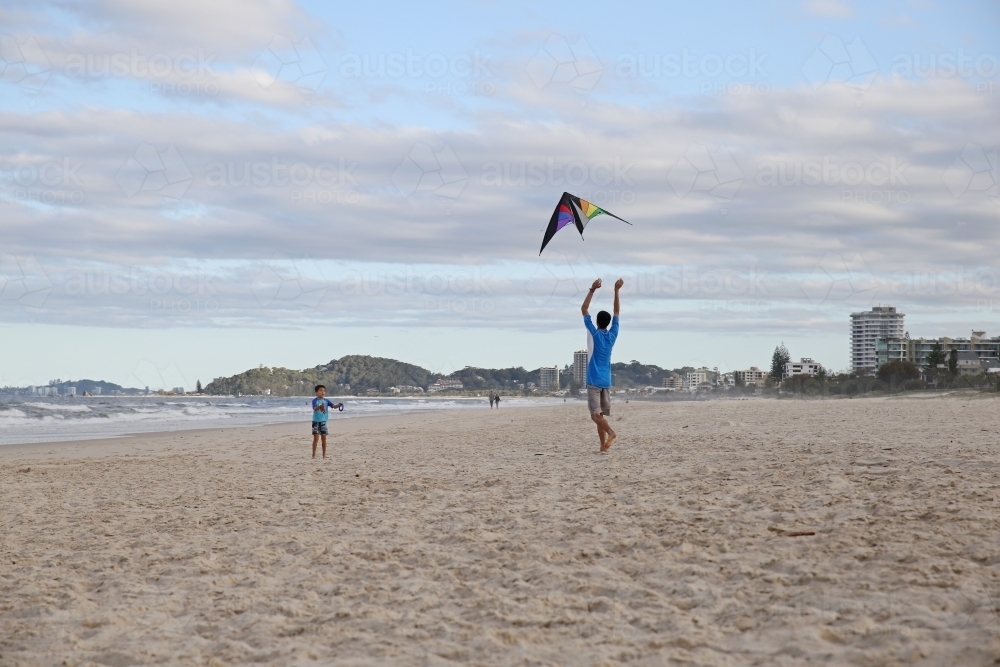 Father and son flying kite on the beach - Australian Stock Image