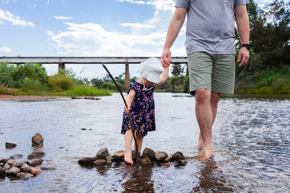 Father and toddler girl wading in Hunter River at Rose Point in Singleton - Australian Stock Image