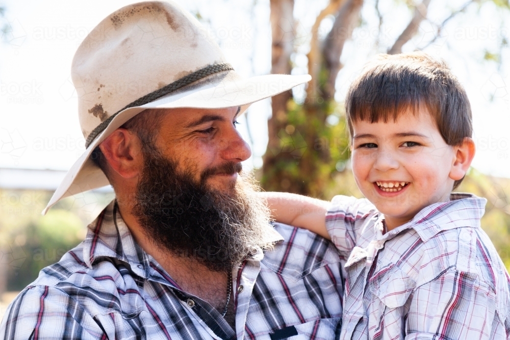 Father and young son hugging outside - Australian Stock Image