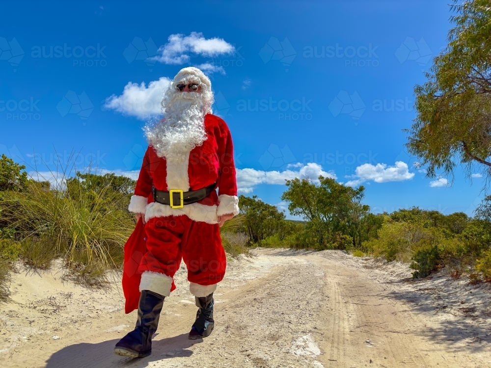 Father Christmas walking down a country track through coastal bushland - Australian Stock Image