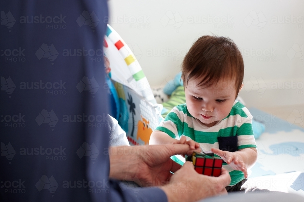 Father playing with baby boy in living room - Australian Stock Image