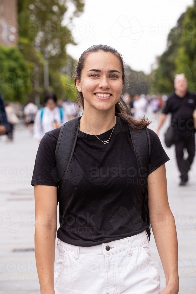 Female aboriginal university student walking through college campus with her backpack - Australian Stock Image