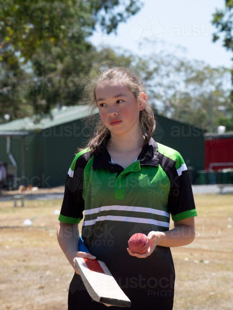 Female cricket player with cricket bat and cricket ball in hand - Australian Stock Image