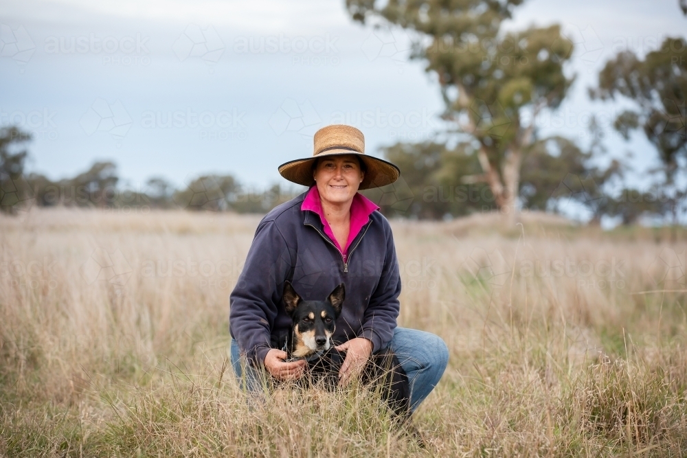 Female farmer with a kelpie in the paddock - Australian Stock Image