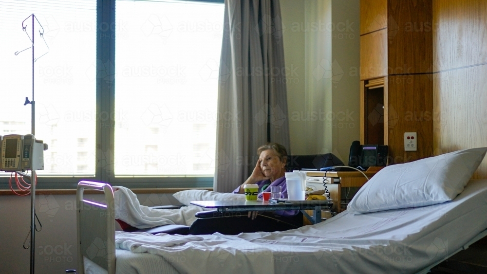 Female patient sitting in chair watching tv - Australian Stock Image