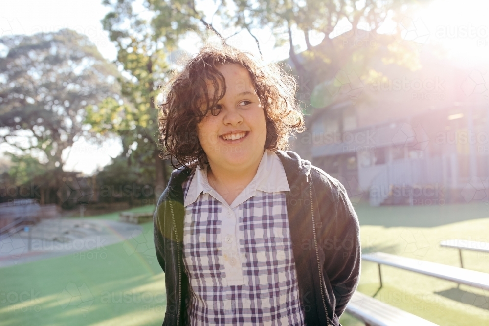 Female school student standing smiling looking away - Australian Stock Image