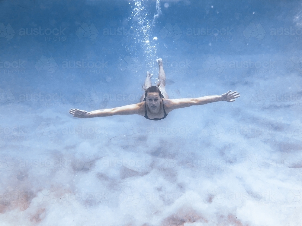 Female swimming underwater in the ocean - Australian Stock Image