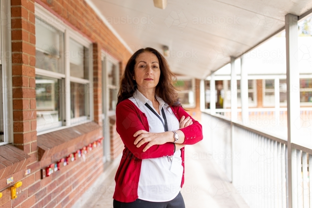 Female Teacher Standing on Balcony with Arms Crossed Looking at Camera - Australian Stock Image