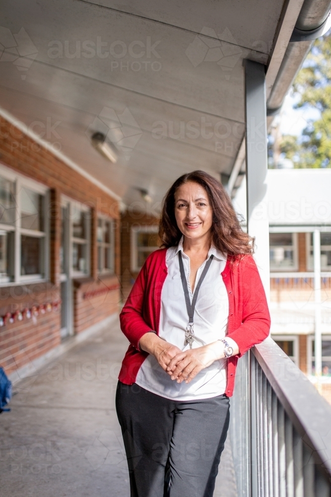 Female Teacher Standing on school Balcony Smiling at Camera - Australian Stock Image