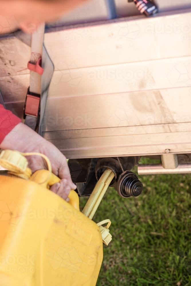 Filling a truck with diesel fuel from a jerry can - Australian Stock Image