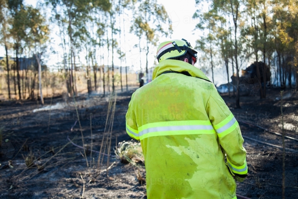 Fire and rescue man in fire brigade at grass fire emergency site - Australian Stock Image