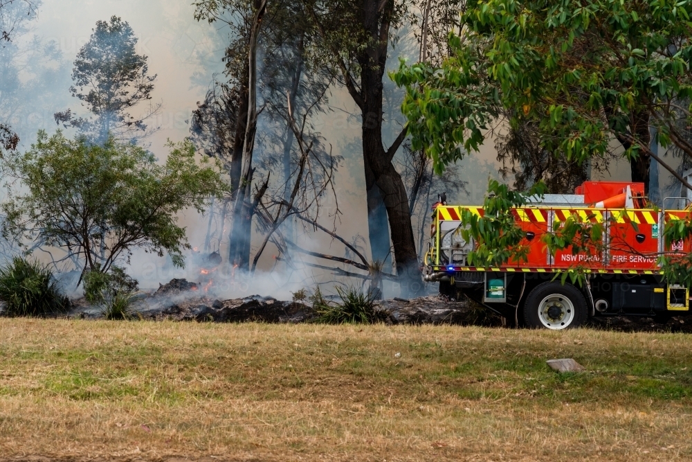 Image of fire truck by bushfire - Austockphoto