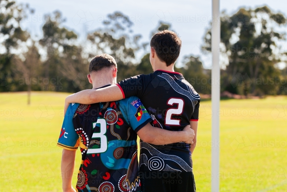 First Nations Australian teammates walking towards goal post after footy game - Australian Stock Image