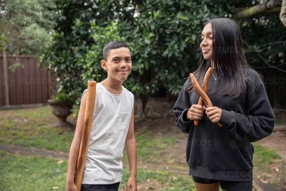 First Nations teenagers holding Indigenous instruments - Australian Stock Image