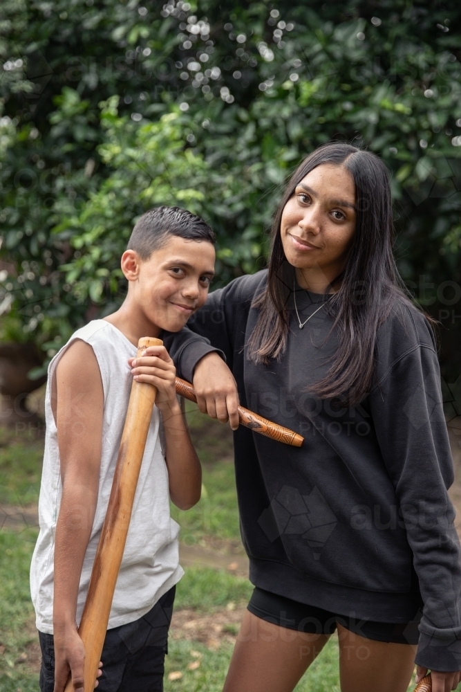 First Nations teenagers holding Indigenous instruments - Australian Stock Image