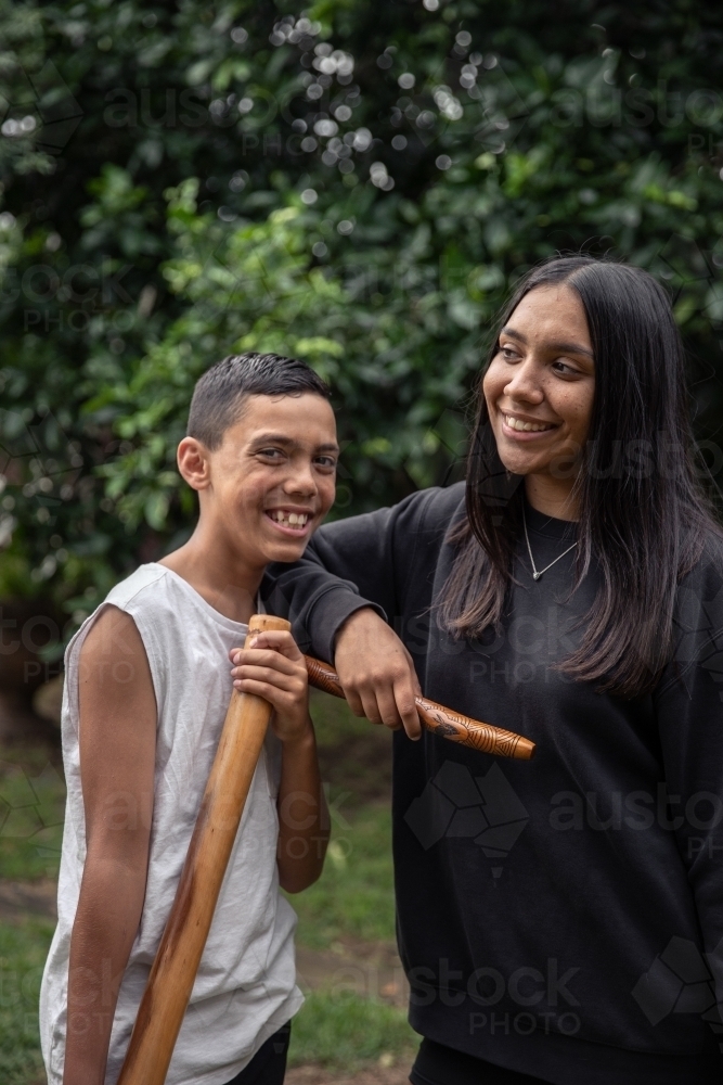 First Nations teenagers holding Indigenous instruments - Australian Stock Image