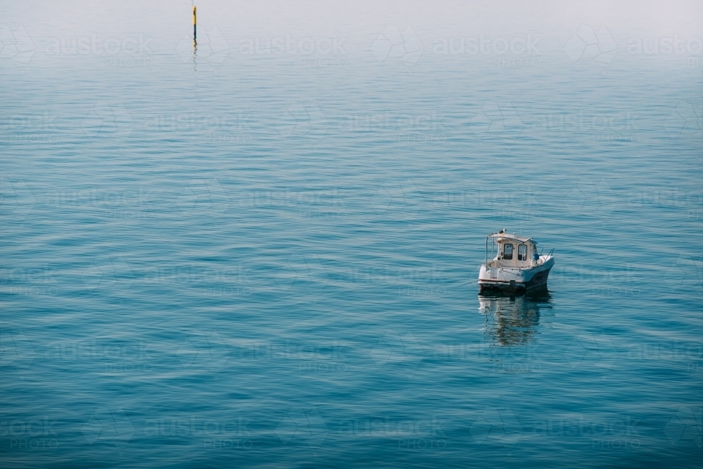 Fishing boat on the calm bay - Australian Stock Image