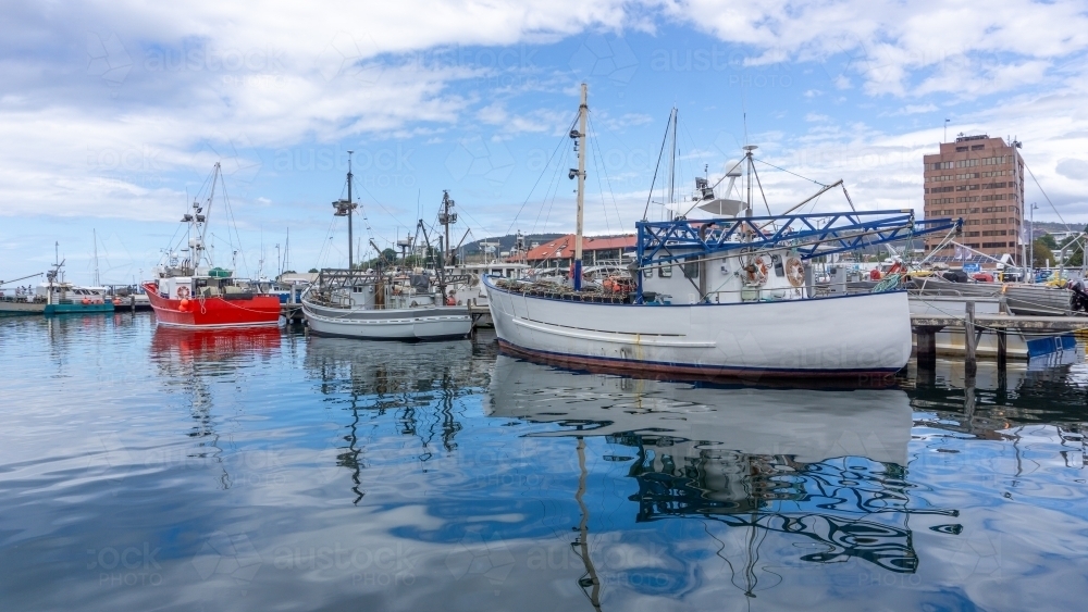 Fishing boats in harbour water on a still day - Australian Stock Image