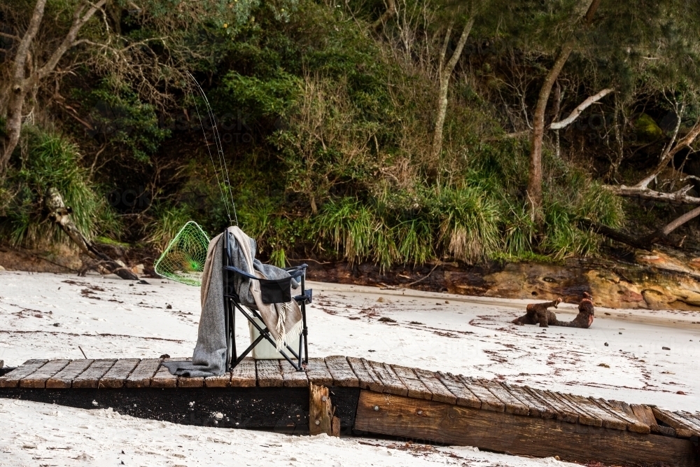 Fishing supplies on a fold-out chair on the beach - Australian Stock Image