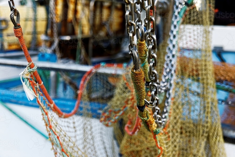 Fishing trawler with silver chains and netting hanging from a fisherman's boat - Australian Stock Image