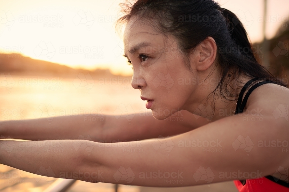 Fit Asian woman doing morning exercise - Australian Stock Image