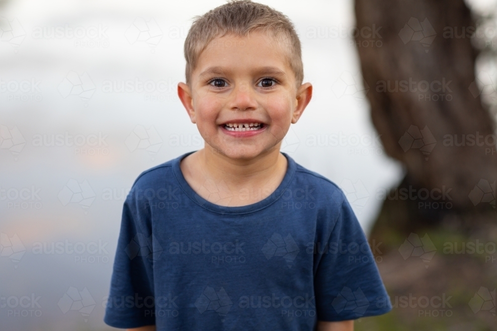 five year old boy grinning at camera - Australian Stock Image