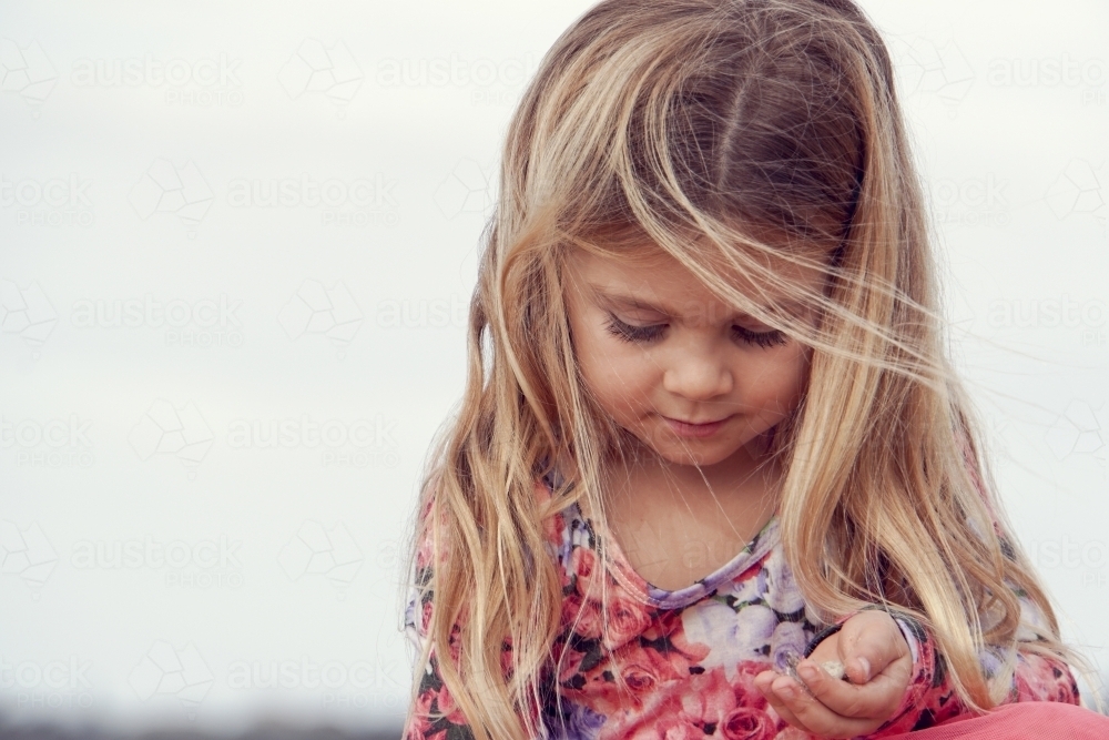 five year old collecting sea shells on beach - Australian Stock Image