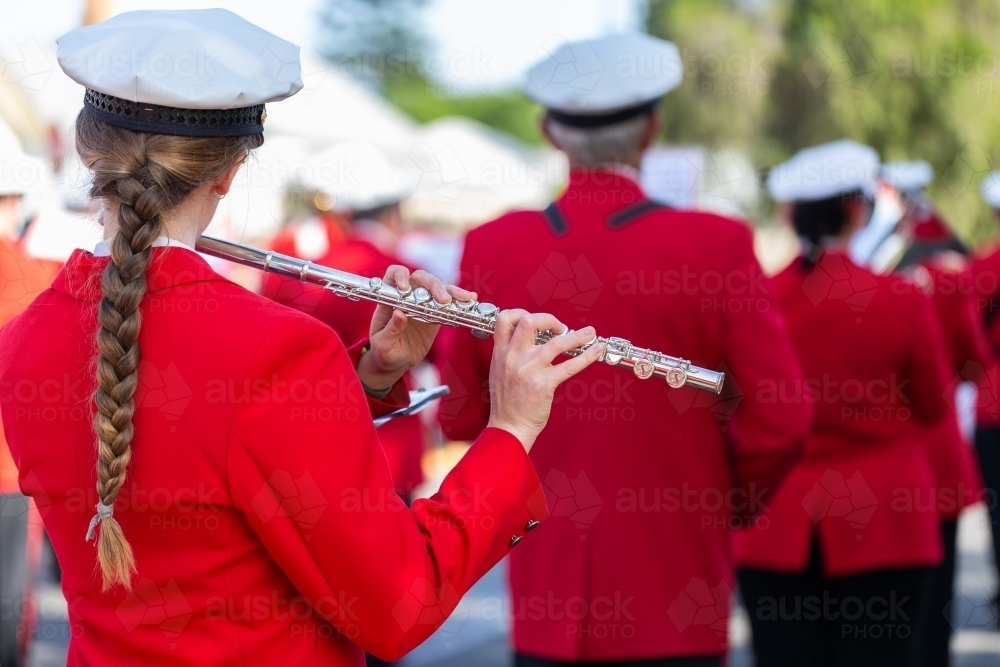 Flautist playing flute in ANZAC Day parade with local band - Australian Stock Image