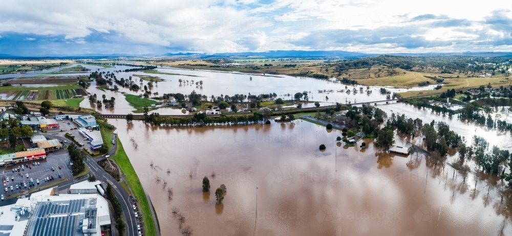 Image of floodwaters covering riverside park beside township rising up ...