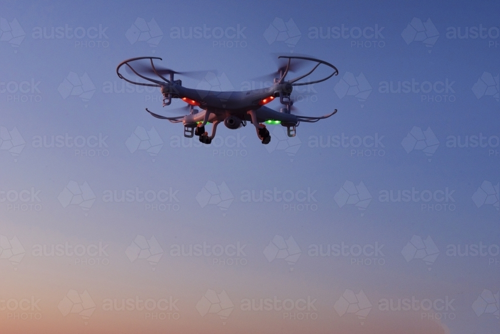 Flying drone in air at sunrise over mountain - Australian Stock Image