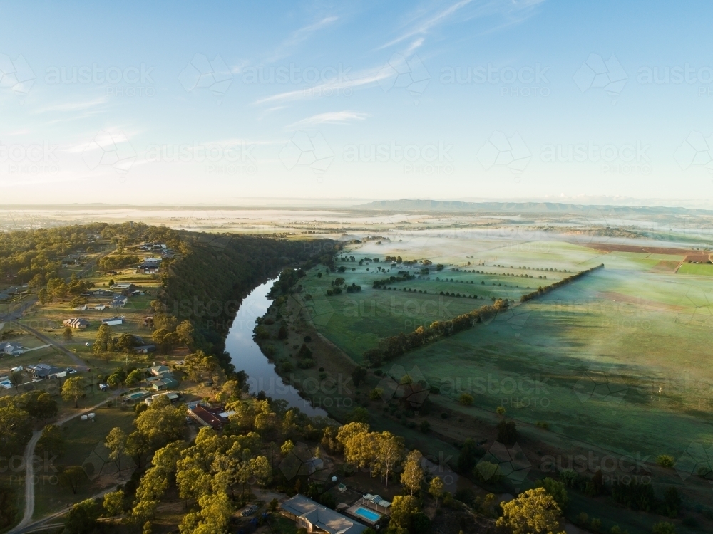 Fog lying over distant farm land and paddocks in early morning - Australian Stock Image