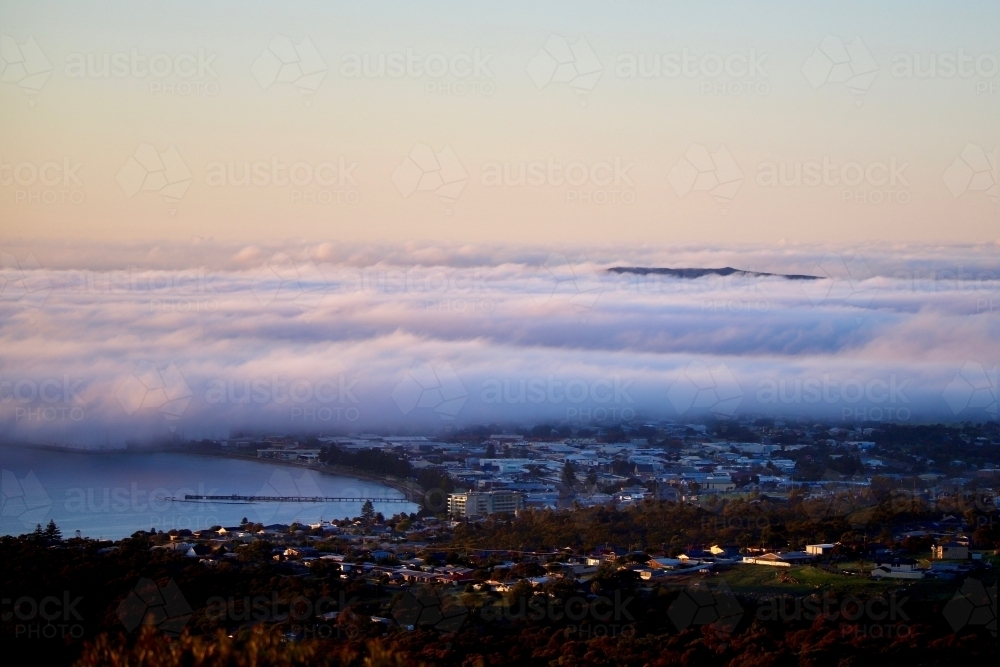 fogs layer sitting low over buildings in an urban area - Australian Stock Image