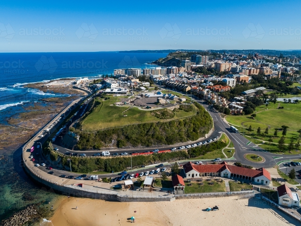 Fort Scratchley in Newcastle on sunlit day, Nobbys beach surf pavilion below seen from Aerial view - Australian Stock Image